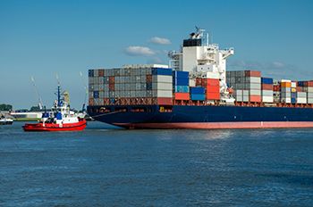 Cargo ship in the water with a blue sky