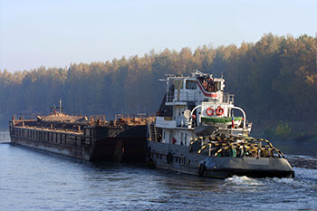 Large boat in the water with a forest in the distance