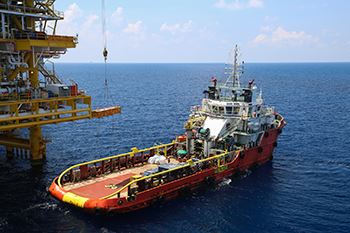 Offshore Injury Boat sitting in a large open water next to a crane